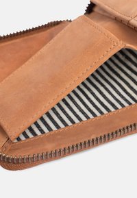 Brown leather wallet with a zipper closure. Interior features striped fabric lining. Smooth texture with stitching details.