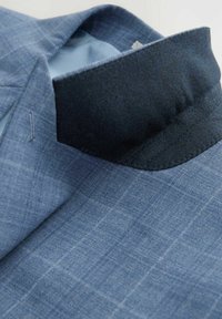 Hellblaues Blazer aus strukturiertem Stoff mit Karomuster und einem kragen aus dunkelblauem Filz. Zu den Details gehören ein schmaler Revers und ein Innenfutter.