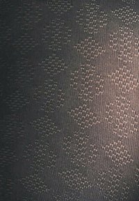 Collant neri con motivo a diamante, caratterizzati da una leggera lucentezza e realizzati in un tessuto elastico e liscio.