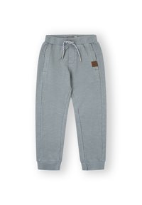Pantalones de chándal grises con cinturilla elástica, cordón ajustable, bolsillos laterales, puños estrechos y un parche de cuero marrón.
