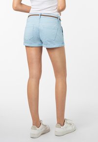 Lichtblauwe denimshorts met een omgeslagen zoom, met twee achterzakken en een gevlochten bruine riem. De stof lijkt glad en casual.