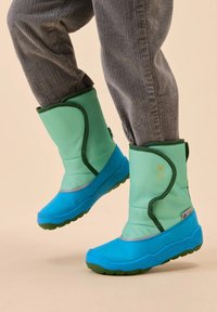 Grüne und blaue isolierte Kinderstiefel mit einem weichen Obermaterial und strukturierten Gummisohlen, die ein Logo und kontrastierende Nähedetails aufweisen.