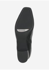 Semelle de chaussure en cuir noir avec une surface lisse, un léger talon et un logo de marque en relief. Forme de orteil arrondi avec un design structuré.