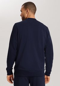 Sudadera de cuello redondo en color navy con mangas largas. Material de algodón suave con un cuello y dobladillo acanalados. Diseño minimalista, sin patrones o gráficos visibles.