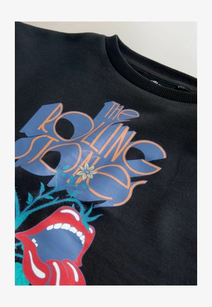 Hanorac negru cu grafică colorată imprimată, inclusiv buze roșii și text stilizat „The Rolling Stones”. Guler rotund cu margine ribbed.