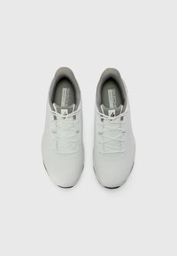 Baskets de sport blanches avec un dessus lisse, à lacets, et des accents gris au niveau du col et de la semelle intérieure. Bout arrondi et semelle texturée.