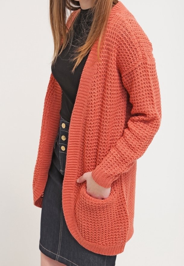 Cardigan corallo a maglia aperta con maniche lunghe, vestibilità comoda e tasche anteriori. Realizzato con filato testurizzato e orli a coste.