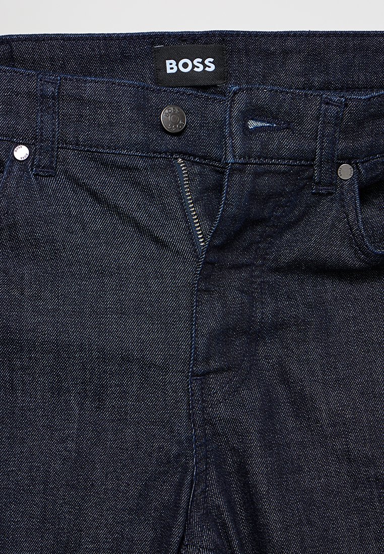 Dunkelblaue Jeans aus Denim mit Reißverschluss, Metallknopf, BOSS-Label an der Taille und klassischem Five-Pocket-Design. Texturiertes Material.