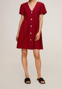 Abito rosso a maniche corte con scollatura a V, chiusura a bottoni e vita arricciata. Realizzato in tessuto leggero, presenta una vestibilità ampia e una superficie liscia.