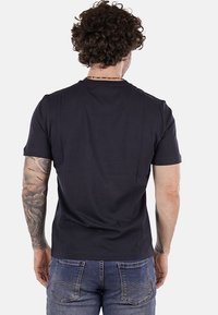 T-shirt nero a maniche corte realizzato in morbido cotone. Semplice scollo rotondo, design aderente e senza marchi o fantasie visibili.
