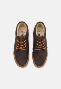 Bruna läderskor för vardagsbruk med orange skosnören och beige foder, med rundad tå och brun gummisula. Märke synligt på insidan.