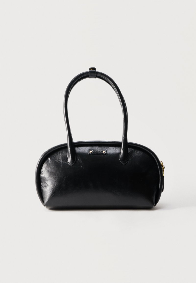 Μαύρη δερμάτινη τσάντα με στρογγυλεμένο σχήμα, διπλές λαβές, χρυστό φερμουάρ και μικρή μεταλλική ετικέτα επωνυμίας μπροστά.