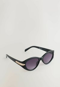 Occhiali da sole neri a forma di occhio di gatto con lenti sfumate viola e dettagli dorati sulle aste. Realizzati in plastica liscia.