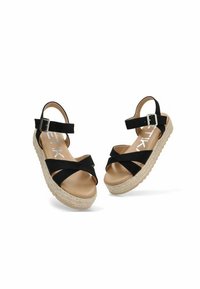 Sandalias espadrilles negras con tiras cruzadas, detalle de hebilla y suela de yute beige. Forro suave en el interior y tacón plano para mayor comodidad.