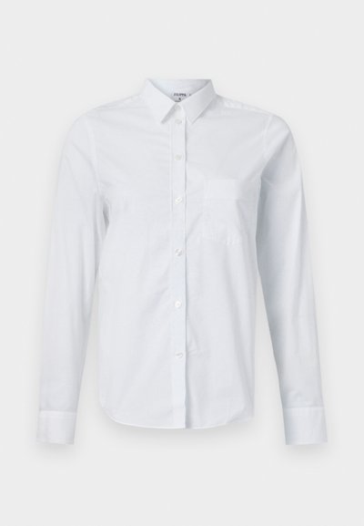 Camicia bianca a maniche lunghe realizzata in cotone. Presenta un'apertura a bottoni sul davanti, colletto a punta e una tasca sul petto sul lato sinistro.