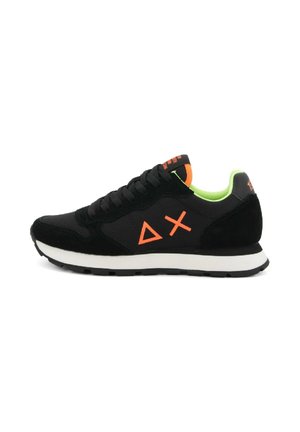Schwarze Sneaker mit neongrüner Innenauskleidung, orangefarbenen Dreiecken und Kreuzsymbolen an der Seite, weißer Zwischensohle und schwarzem Außensohle.