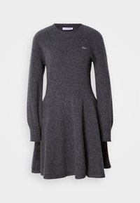 Robe tricotée gris foncé à manches longues avec encolure ronde et logo Lacoste discret sur la poitrine, jupe évasée et poignets côtelés.