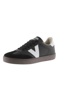 Svart sneakers med mocka och lädermaterial, vita detaljer, snörningsdesign, rund tå och en texturerad grå sula.