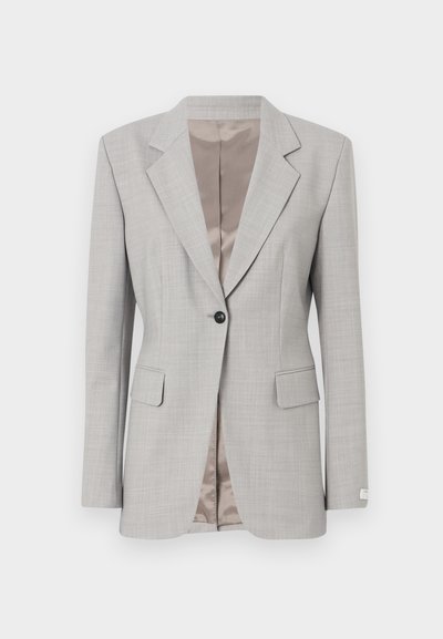 Gaiši pelēks blazer, izgatavots no teksturēta auduma. Iezīmēts ar noberztu apakšmalu, vienu pogu aizdari un divām priekšējām kabatām. Satīna iekšējā oderes apdare.