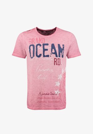Camiseta rosa claro de manga corta con texto gráfico y diseños, que presenta "GRAND OCEAN RD." en azul oscuro con acentos rojos, textura suave.