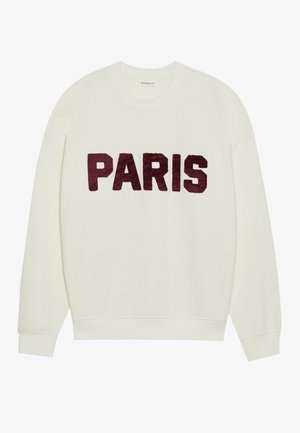 Sudadera color crema con cuello redondo, con grandes letras burdeos "PARIS" bordadas en la parte frontal. Textura suave, corte relajado.