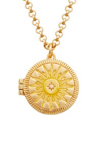 Gouden ketting met een ronde medaillon met een zonnestraalontwerp, een gestructureerd oppervlak en een klein diamantdetail in het midden.