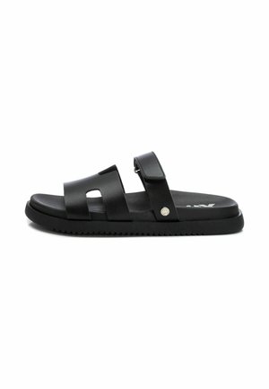 Sandalias negras hechas de material sintético, con dos correas anchas, una ajustable con sistema de cierre de gancho y bucle, y suela texturizada y estriada.