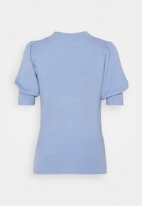 Ljusblå stickad tröja med puffärmar, hög hals och ribbad textur. Bakdetaljen har böjda sömmar.