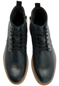 Ciemnoniebieskie skórzane botki za kostkę o gładkim wykończeniu, okrągłym nosku, sznurowanej cholewce, bocznym suwak i kontrastującej beżowej podeszwy z gumy.