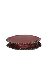 Borsa rotonda in pelle rossa con bordo metallico intrecciato e chiusura a zip. Texture liscia con dettagli di cucitura lungo il perimetro.