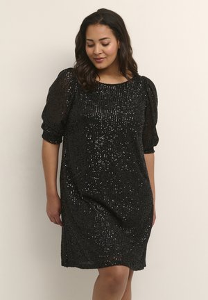 Black sequin dress with a relaxed fit, round neckline, and puffed sleeves. Texture features numerous shimmering sequins across the surface.