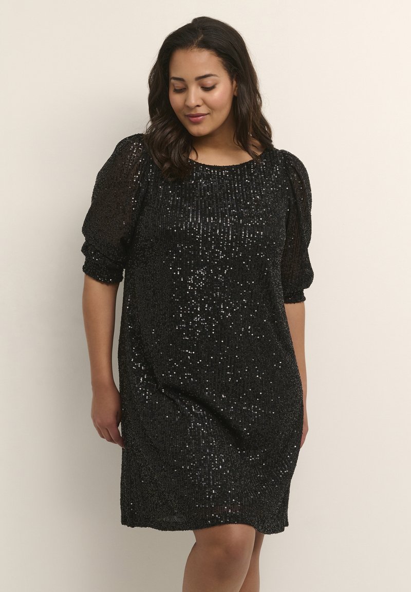 Robe en sequins noirs avec une coupe décontractée, col rond et manches bouffantes. La texture présente de nombreux sequins scintillants sur la surface.