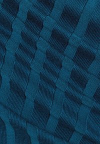 Blau gemusteter Stoff mit einem gerippten Muster, das abwechselnd erhabene und flache Abschnitte zeigt und so einen strukturierten, dreidimensionalen Look erzeugt.