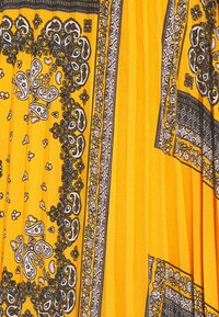 Tissu jaune avec des motifs complexes de paisley noir et blanc ainsi que des motifs floraux. Présente une apparence texturée avec un design fluide.