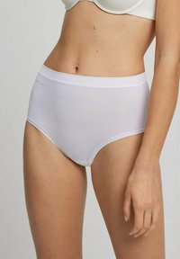 Bragas blancas de cintura alta hechas de tela suave, con una cinturilla sin costuras y costuras mínimas para mayor comodidad.