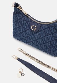 Borsa in denim blu navy trapuntato con hardware dorato, accento con logo e manici rimovibili: uno in catena e uno in tessuto blu navy solido.