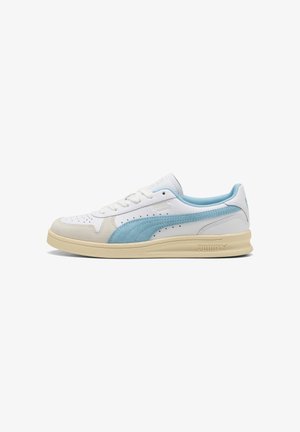 Weißer Sneaker mit hellblauen Akzenten und einem Wildlederstreifen. Er verfügt über eine perforierte Zehenpartie, runde Schnürsenkel und eine strukturierte cremefarbene Sohle.