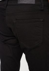 Svarta denimjeans med smal passform, med en sydd bakficka och en läderetikett präglad med "GABBA" på midjebandet.