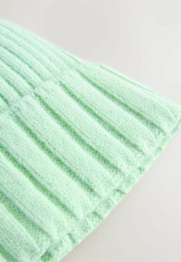 Mintgrøn strikhue med lodret ribbet tekstur, blødt materiale og pæn kantdetalje.