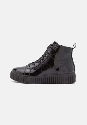 Black glossy high-top sneaker with side zipper, lace-up front, pull tab at heel, and thick ridged sole on white background.