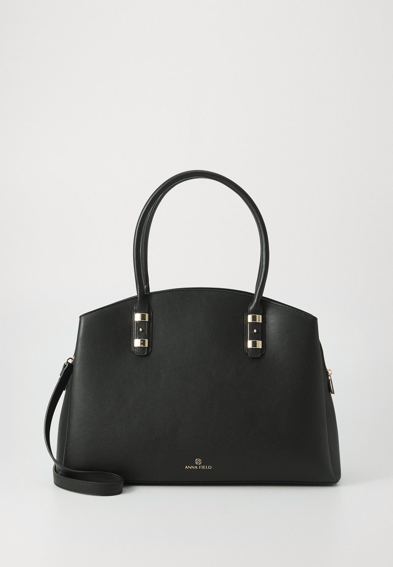 Black synthetic handbag with two rounded handles, gold-tone hardware accents, and a zippered compartment. Smooth texture with a structured shape.