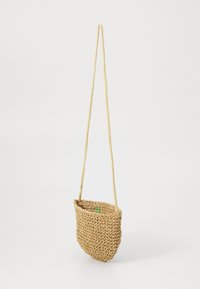 Geflochtene Stroh-Crossbody-Tasche mit gebogener Form, natürlicher Farbe und langem Seilriemen. Sie hat einen kleinen grünen Akzent im Inneren.