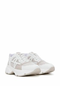 White and beige athletic sneakers featuring mesh panels, thick rubber soles, and contrasting accents on the sides and toe box.