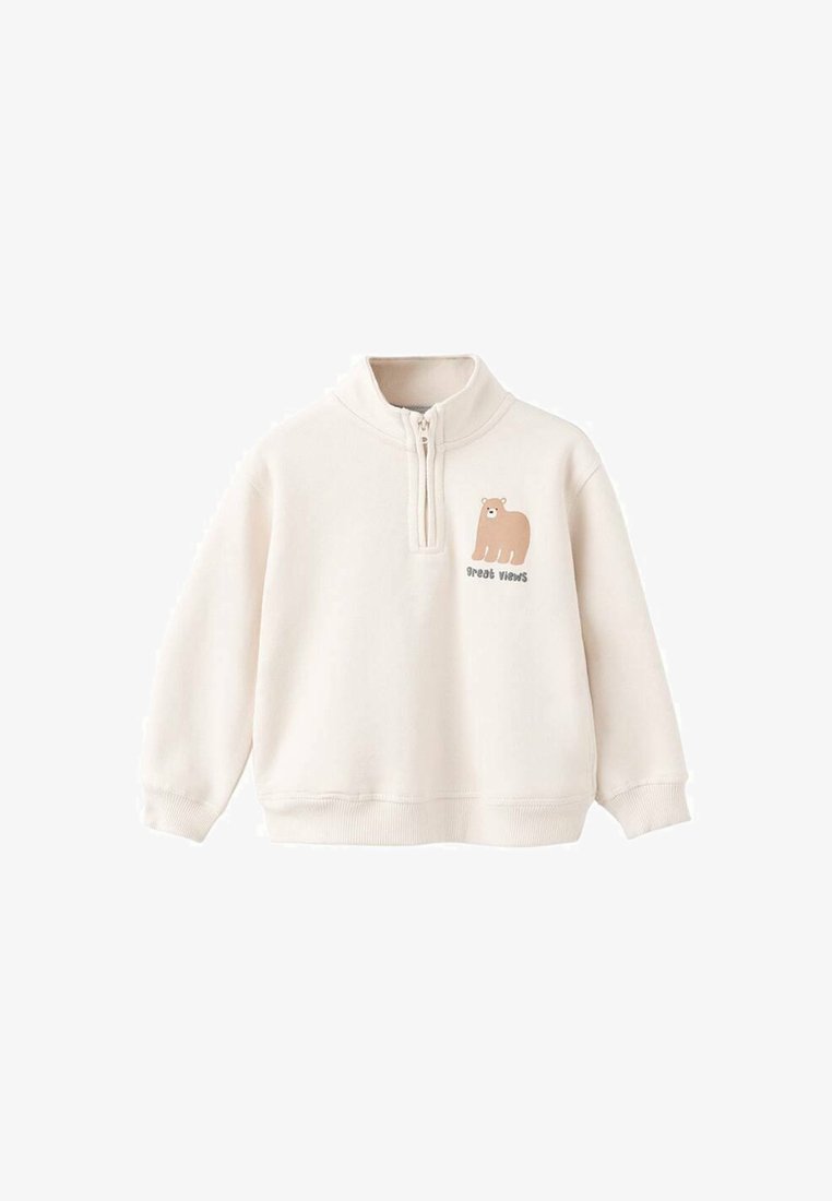 Felpa color crema con colletto a metà zip, caratterizzata da una grafica di un orso marrone e il testo "ottime viste" sotto di essa. Materiale morbido con polsini a coste.