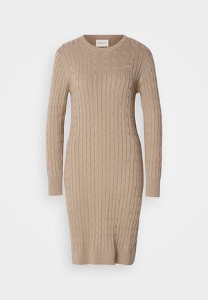 Rochie tricotată bej, cu un model texturat tip cablu, mâneci lungi și o guler rotund. Detaliu subtil cu logo pe piept.