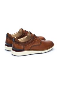 Zapatos de cuero marrón con un acabado suave, con acentos de textil y ojetes rojos. Suelas acolchadas con una mediasuela de color crema.