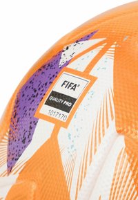 FIFA Quality Pro nogometna lopta s narančastom površinom i ljubičastim, bijelim i tirkiznim naglascima, teksturirana za bolje prianjanje i izdržljivost.