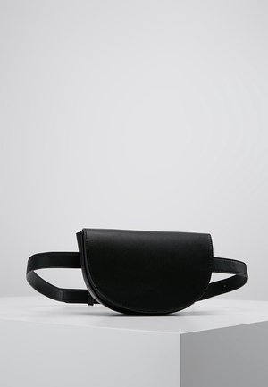 Musta nahkainen vyölaukku, jossa on kaareva läppä ja säädettävä olkahihna, esillä valkoisella jalustalla harmaata taustaa vasten.