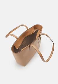 Brun läderväska med en slät yta, två axelremmar och en öppen topp som visar en beige insida med en dragkedjeficka.