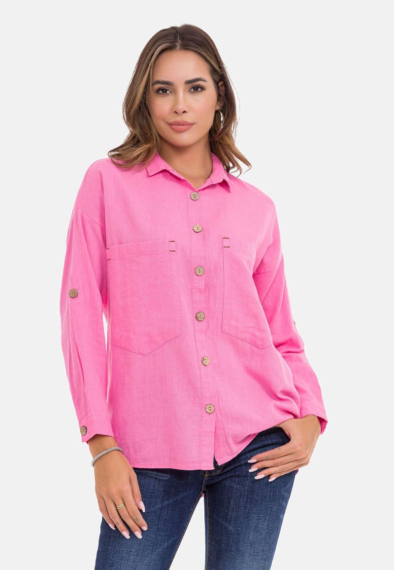 Rosa Hemd mit Knöpfen aus leichtem Stoff, ausgestattet mit zwei Fronttaschen, Holzknöpfen und langen, hochgestellten Ärmeln.
